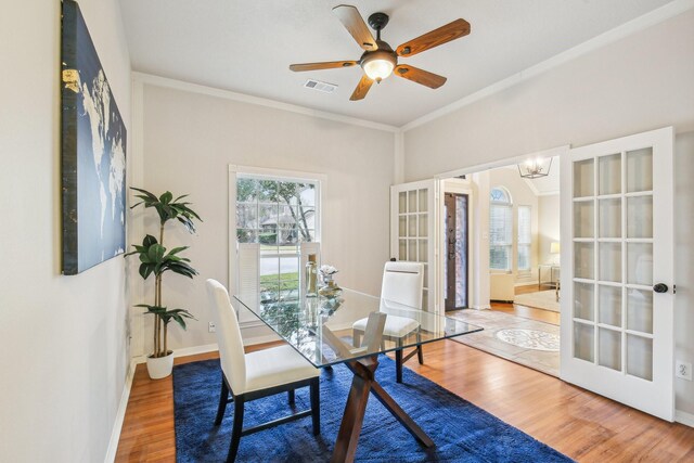 dining area with ceiling fan with notable chandelier, wood-type flooring, ornamental molding, and french doors