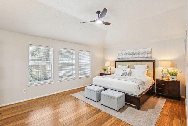 bedroom with baseboards, lofted ceiling, wood finished floors, and a ceiling fan