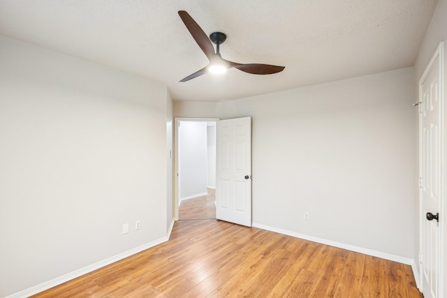 unfurnished bedroom featuring light wood-style flooring, a ceiling fan, and baseboards