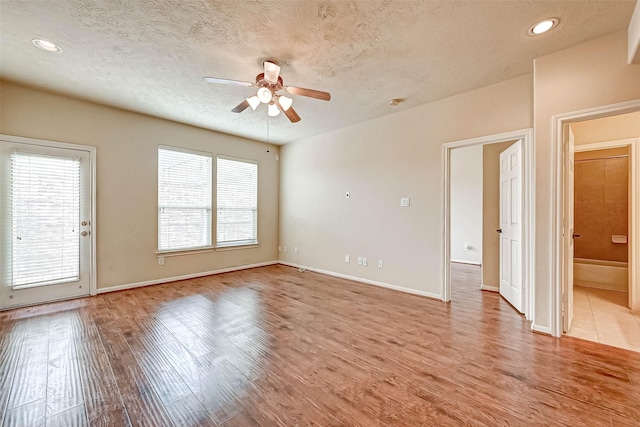 empty room featuring ceiling fan, a textured ceiling, and light hardwood / wood-style floors