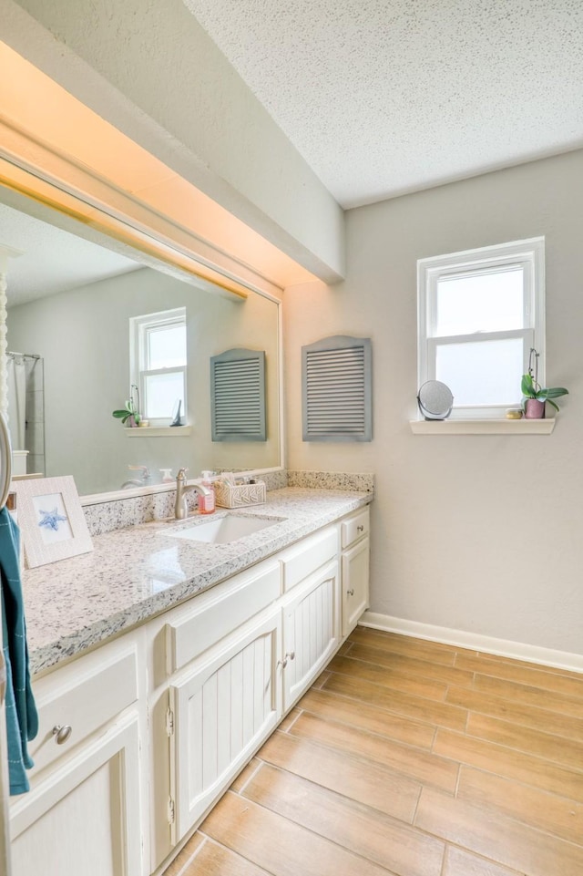 bathroom featuring vanity, hardwood / wood-style floors, and a textured ceiling