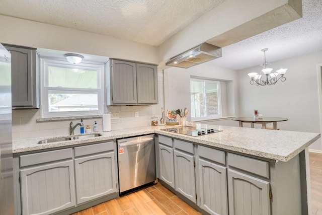 kitchen with sink, a textured ceiling, black electric cooktop, stainless steel dishwasher, and kitchen peninsula