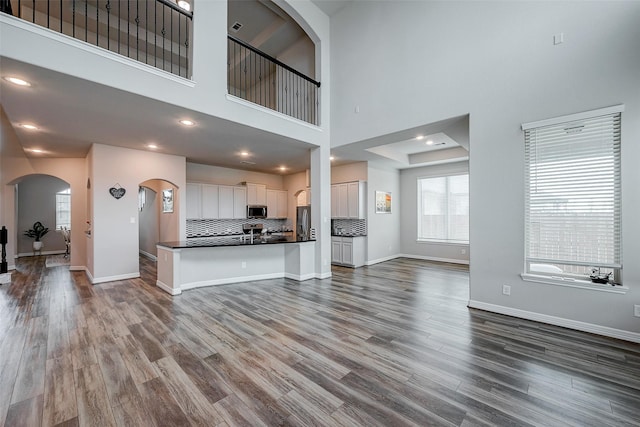 unfurnished living room with hardwood / wood-style flooring and a high ceiling