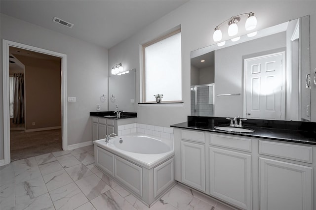 bathroom with vanity and shower with separate bathtub