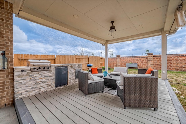 wooden deck featuring an outdoor living space, grilling area, ceiling fan, and an outdoor kitchen