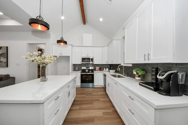 kitchen featuring appliances with stainless steel finishes, beam ceiling, hanging light fixtures, and white cabinets