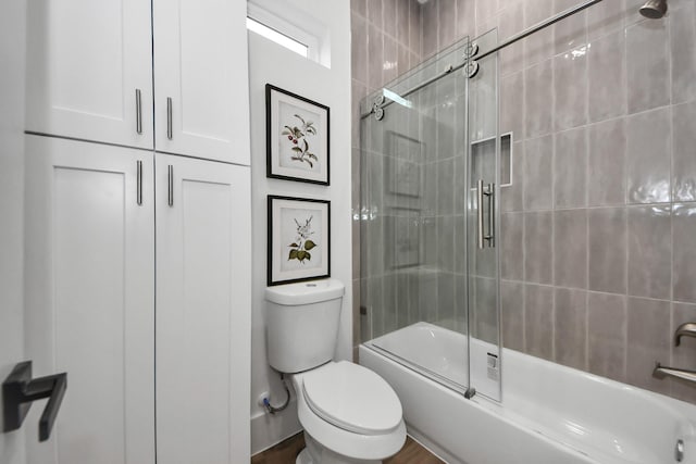 bathroom featuring bath / shower combo with glass door and toilet