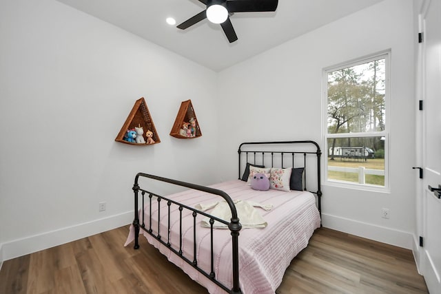 bedroom featuring multiple windows, hardwood / wood-style flooring, and ceiling fan