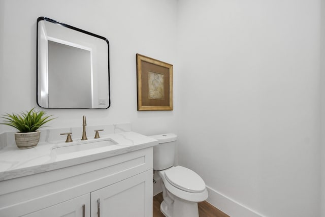 bathroom featuring vanity, hardwood / wood-style flooring, and toilet