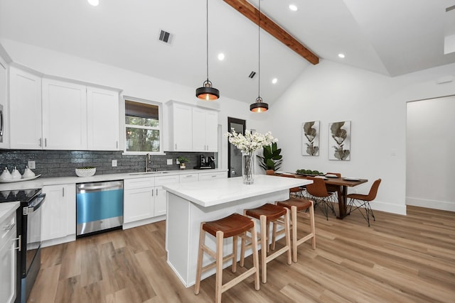 kitchen with white cabinetry, dishwasher, a kitchen island, and sink