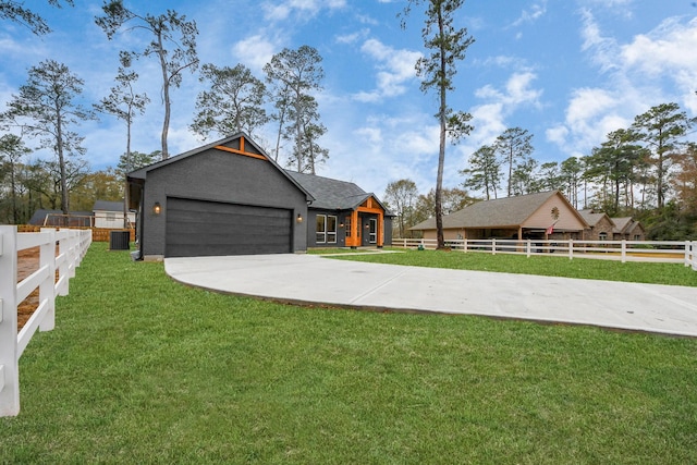 view of front of house featuring a garage, a front yard, and central air condition unit