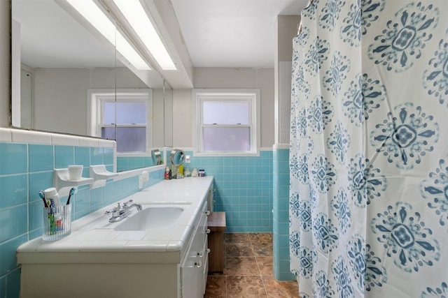 bathroom featuring tile walls, a skylight, a shower with shower curtain, vanity, and tile patterned floors