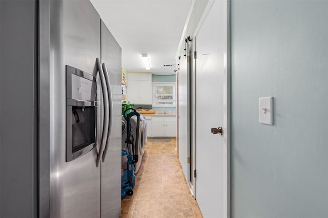 hall featuring light tile patterned floors, washer / clothes dryer, and sink