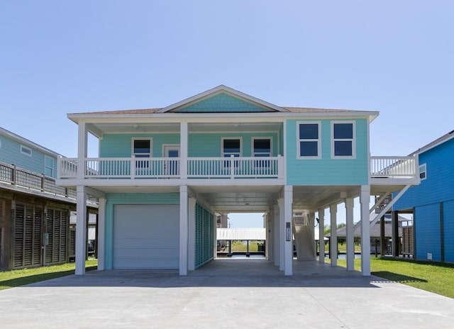 raised beach house featuring a carport, a garage, and a balcony