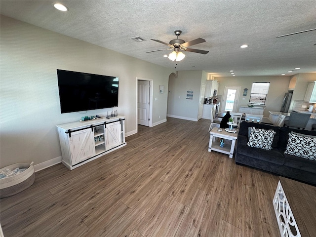 living room featuring hardwood / wood-style flooring, a textured ceiling, and ceiling fan