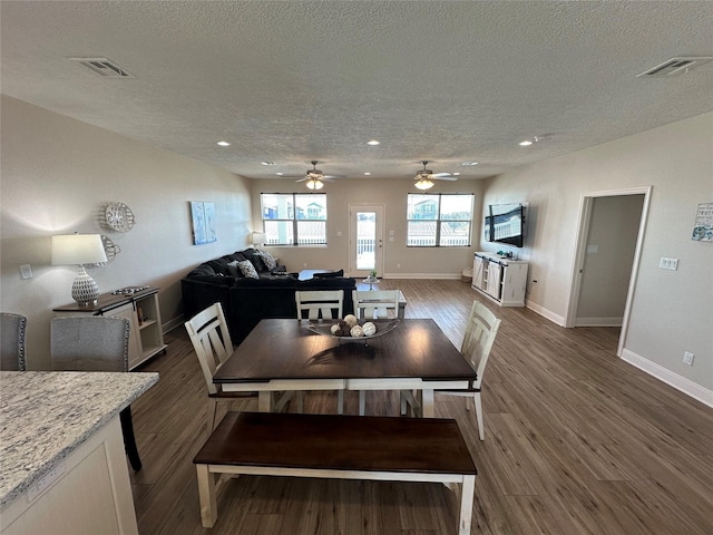 dining space featuring dark wood-type flooring and a textured ceiling