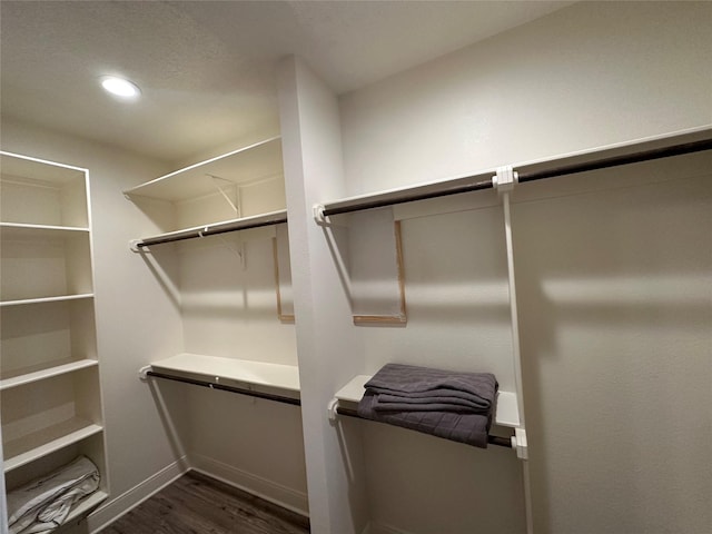 walk in closet with dark hardwood / wood-style floors