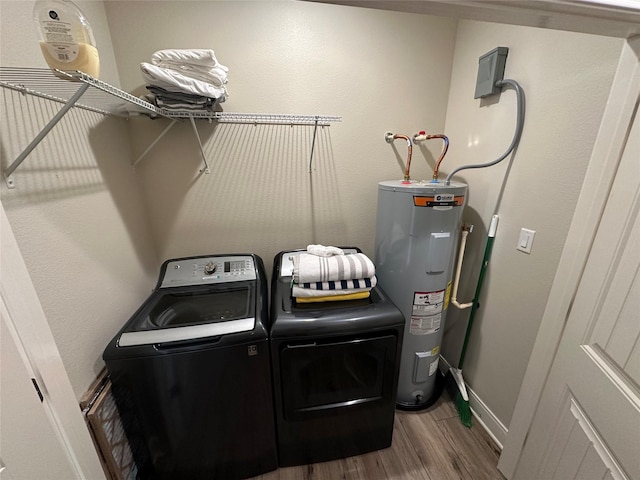 laundry area featuring washer and clothes dryer, electric water heater, and wood-type flooring