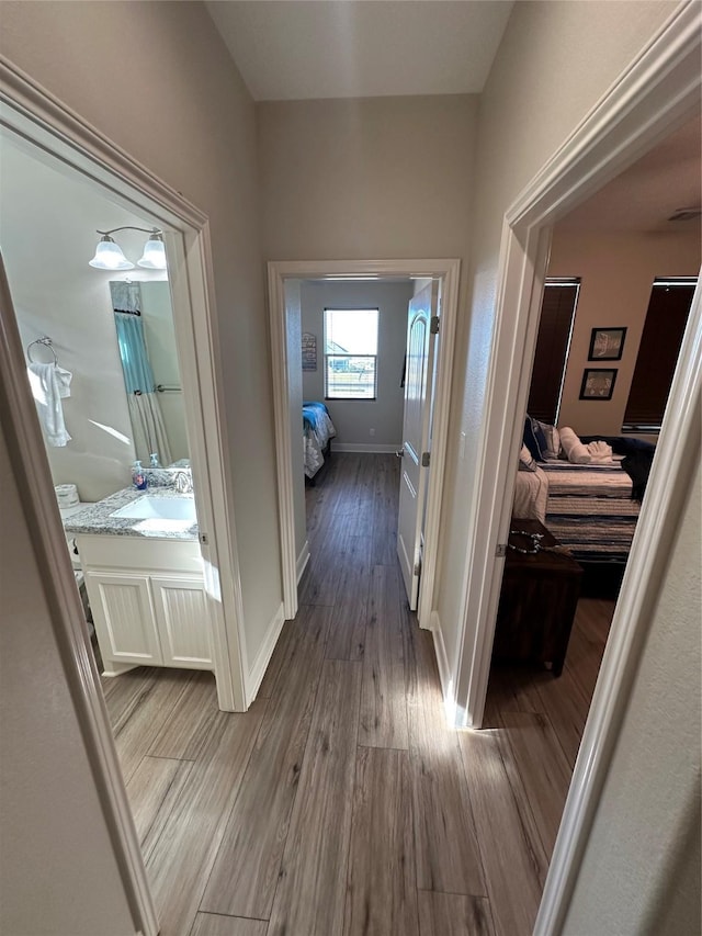 hallway featuring sink and hardwood / wood-style floors