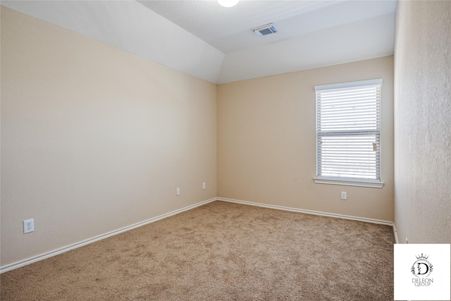 carpeted spare room with vaulted ceiling