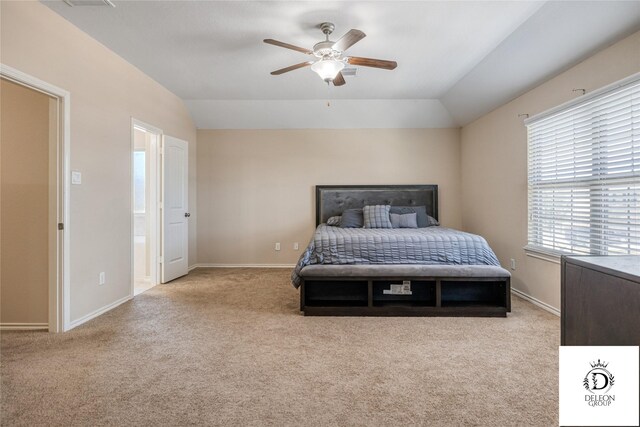 carpeted bedroom featuring connected bathroom, vaulted ceiling, and ceiling fan