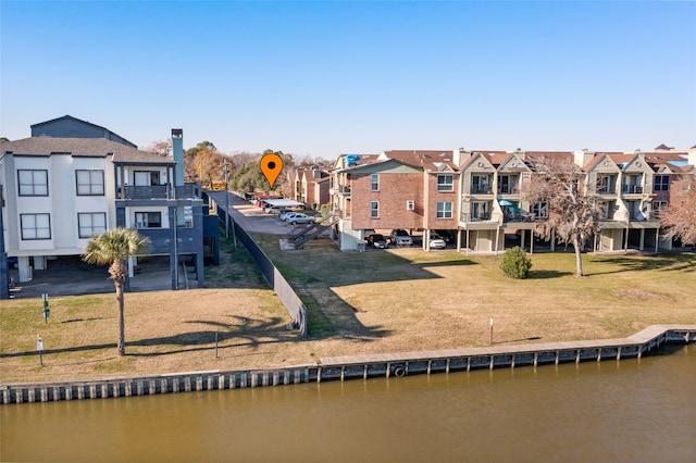 rear view of property with a yard and a water view