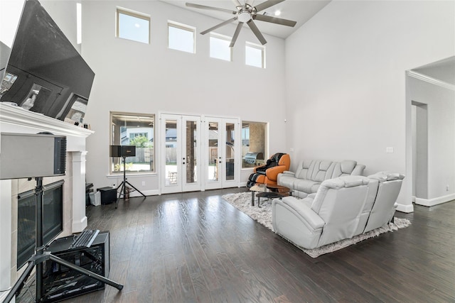 living room with french doors, a high end fireplace, dark hardwood / wood-style floors, and a high ceiling