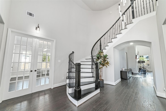 entryway with french doors, dark hardwood / wood-style floors, and a high ceiling