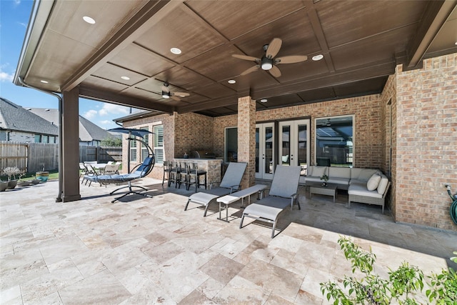 view of patio / terrace featuring exterior bar, outdoor lounge area, ceiling fan, and french doors