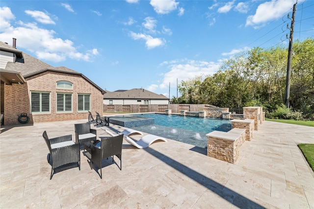 view of swimming pool featuring a patio, pool water feature, and an in ground hot tub