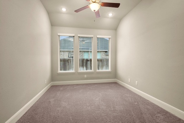 carpeted spare room featuring ceiling fan and vaulted ceiling