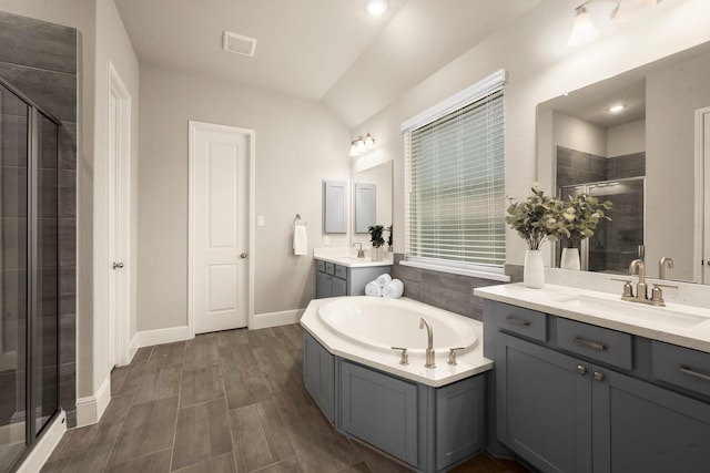 bathroom featuring vanity, vaulted ceiling, and shower with separate bathtub