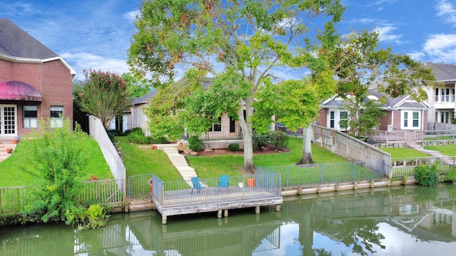 dock area with a lawn and a water view