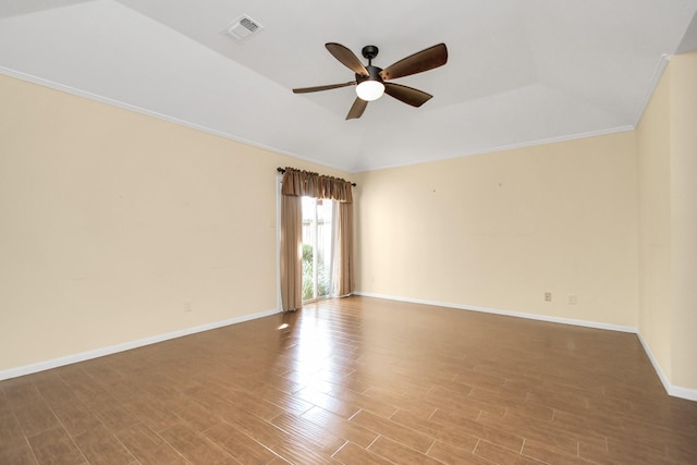 empty room featuring ceiling fan, lofted ceiling, and a tray ceiling