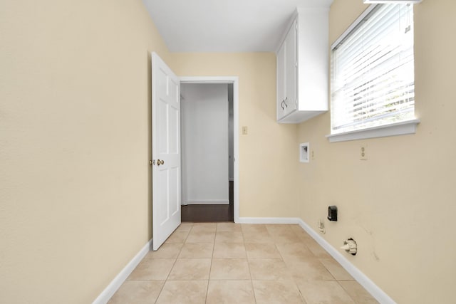 washroom featuring light tile patterned floors, hookup for a washing machine, and cabinets