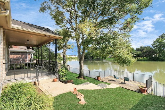 view of yard featuring a patio, ceiling fan, and a water view