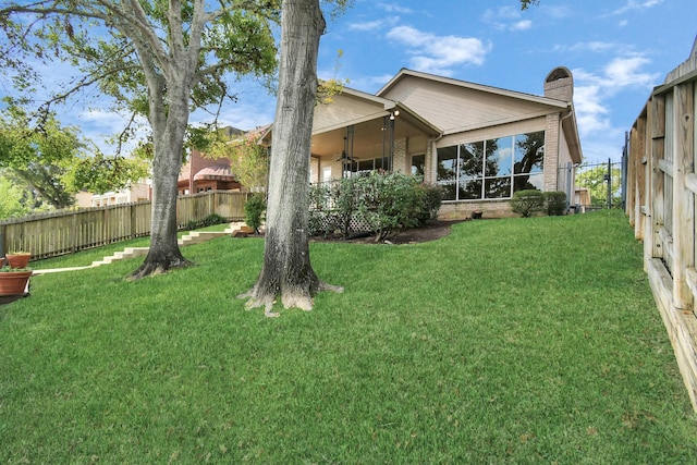 rear view of house with a yard and ceiling fan