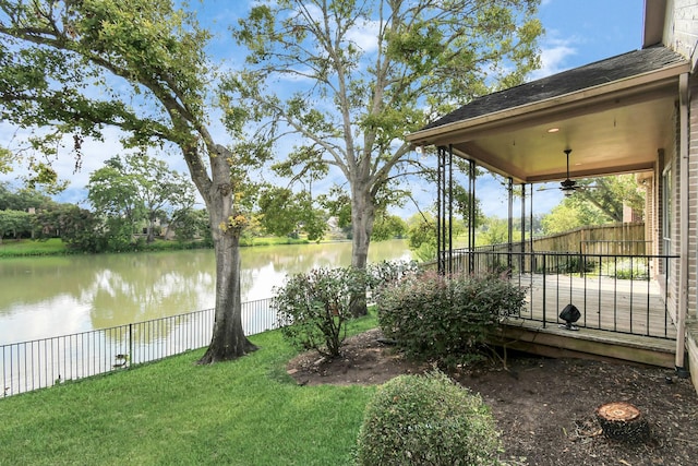 view of yard with ceiling fan and a water view