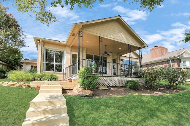 back of house featuring a porch, ceiling fan, and a lawn