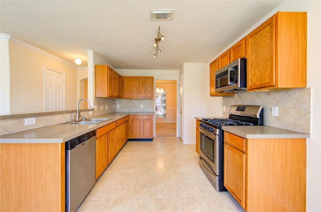 kitchen featuring appliances with stainless steel finishes, sink, decorative backsplash, light tile patterned floors, and crown molding