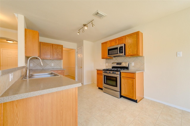 kitchen with stainless steel appliances, tasteful backsplash, sink, and light tile patterned floors