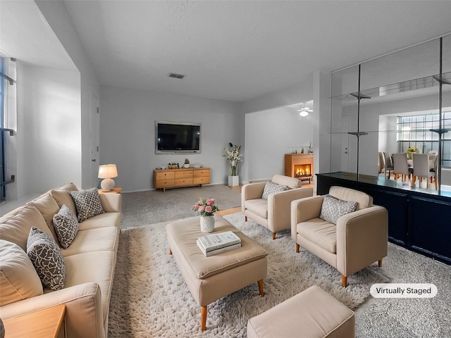 carpeted living room featuring a textured ceiling and ceiling fan