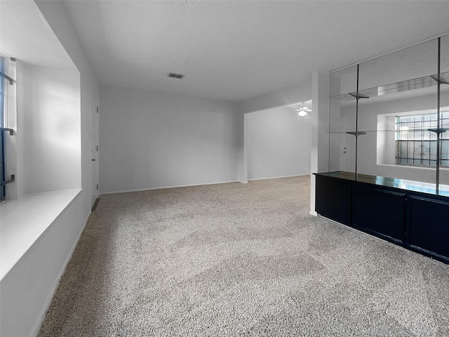 carpeted empty room featuring ceiling fan and a textured ceiling