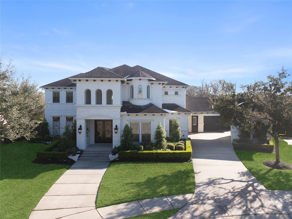 mediterranean / spanish-style house with a garage and a front lawn