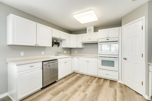 kitchen featuring double oven, white cabinetry, sink, stainless steel dishwasher, and light hardwood / wood-style flooring