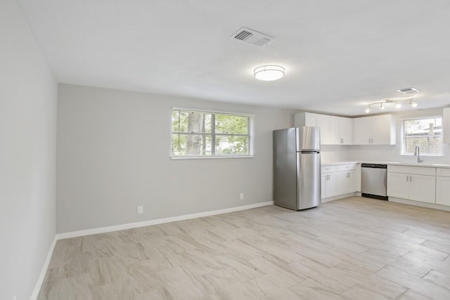 kitchen featuring appliances with stainless steel finishes, sink, and white cabinets