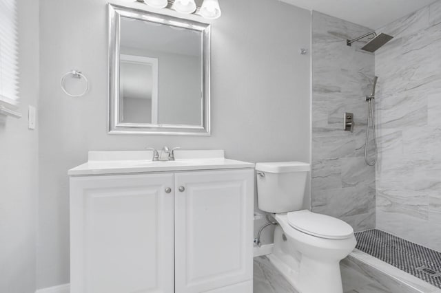 bathroom with vanity, toilet, and a tile shower