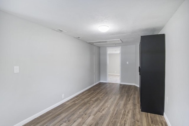 unfurnished room featuring hardwood / wood-style floors and a textured ceiling