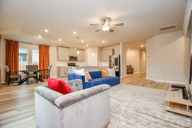 living room featuring light hardwood / wood-style floors and ceiling fan