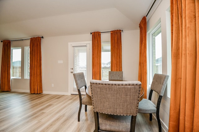 dining space with lofted ceiling and light hardwood / wood-style flooring